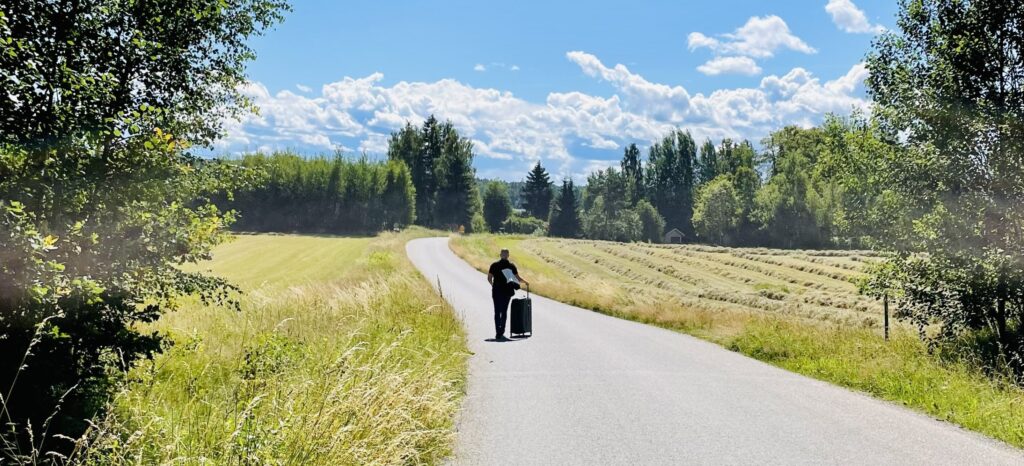 Symbolik för att avveckla företag - en person som går med en väska längs en väg